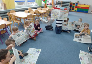 Dzieci bawią się gazetami
