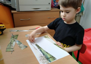 Chłopiec układa obrazek z części