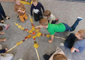 Dzieci wykonują pracę przestrzenną z darów jesieni