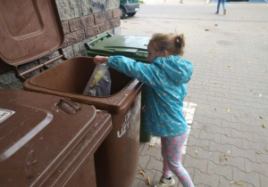 Dziewczynka segreguje śmieci