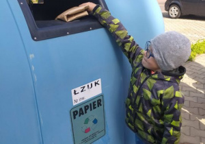 Chłopiec wyrzuca papier