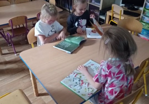Dziewczynki przy stoliku oglądają książki