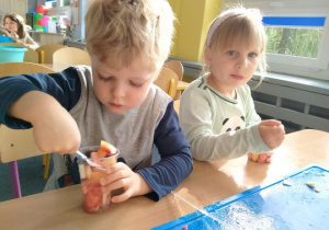 Dzieci jedzą sałatkę owocową