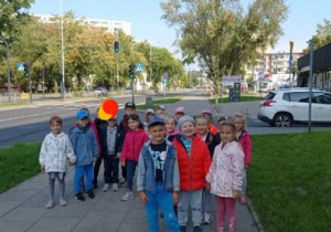 Grupa dzieci stoi przy przejściu dla pieszych