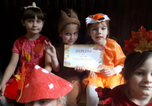 Dziewczynki pokazują dyplom uczestnictwa w balu