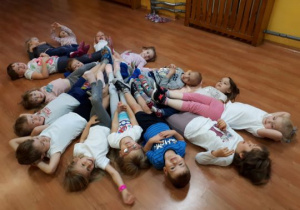 Dzieci leżą na podłodze w okręgu