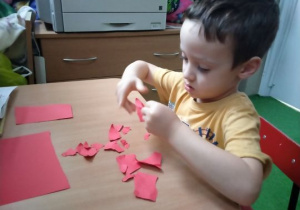 Chłopiec wydziera kolorowy papier