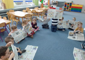 Dzieci bawią się gazetami