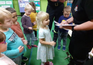 Strażak daje dziewczynce dyplom