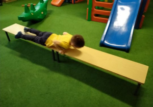 Chłopiec wykonuje ćwiczenie na ławeczce