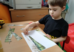 Chłopiec układa obrazek z części