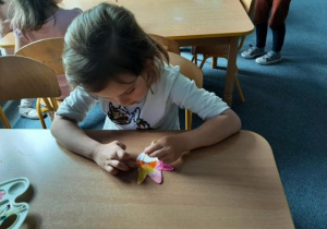 Dzieci ozdabiają kwiatka za pomocą patyczków