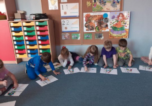 Dzieci układają literę A z guzików