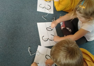 Dzieci układają literkę E za pomocą sznurowadła