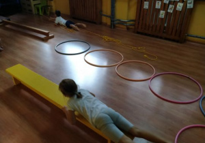 Dzieci wykonują ćwiczenia na ławeczce