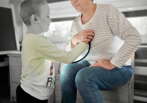 Chłopiec bada nauczycielkę stetoskopem