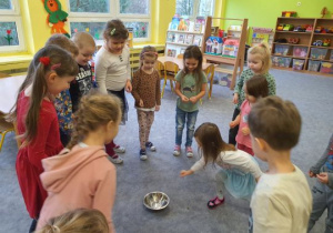 Dzieci wrzucają monetę do miski