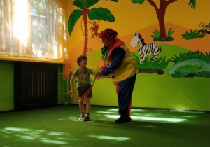 Chłopiec skacze przez skakankę z klaunem