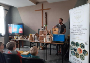 Prowadzący prezentuje przedmioty związane z pszczelarstwem