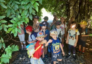 Dzieci stoją w roślinnym tunelu