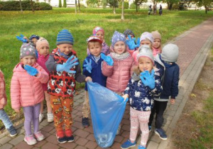 Dzieci pokazują worek ze śmieciami