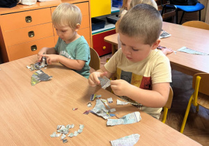 Dzieci wydzierają kawałki gazety