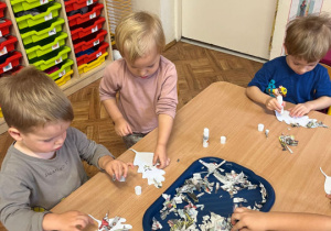 Dzieci wyklejają liście z kawałków gazety