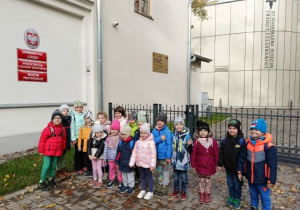 Dzieci pozują do zdjęcia przed budynkiem muzeum
