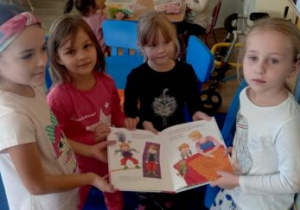 Dziewczynki pozują do zdjęcia z książką