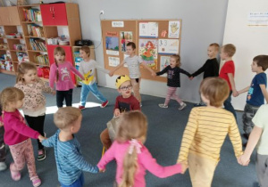 Dzieci tańczą w kole i śpiewają koledze sto lat