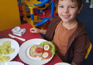 Chłopiec pokazuje wesołą kanapkę