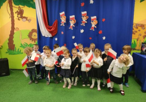 Dzieci pozują do zdjęcia z flagami polski