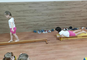 Dziewczynki ćwiczą na równoważni i ławeczce