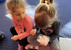 Dziewczynki dotykają kostki lodu