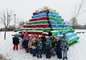Dzieci pozują do zdjęcia przy piramidzie z prezentów