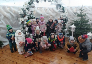 Dzieci stoją przy świątecznej dekoracji