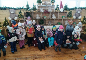 Dzieci stoją przy świątecznej dekoracji