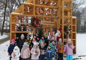 Dzieci stoją przed chatką świąteczną