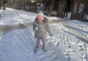 Dziewczynka dmucha na śnieg