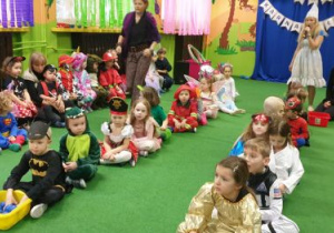 Dzieci siedzą w dwóch rzędach podczas konkursu