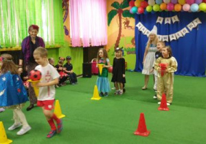 Dzieci biorą udział w konkursie z pachołkami i piłką