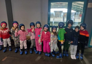 Dzieci stoją przed wejściem na lodowisko