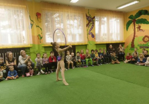 Dziewczynka wykonuje ćwiczenia z hulahop