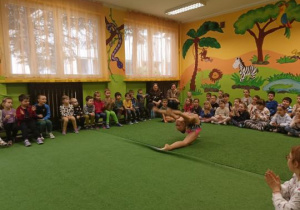 Dziewczynka prezentuje ćwiczenia gimnastyczne