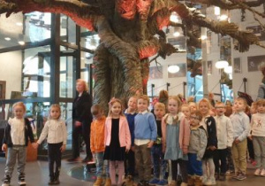 Dzieci stoją w holu teatru pod interaktywnym drzewem