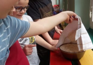 Dzieci przykrywają miseczkę ściereczką