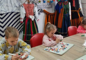 Dzieci dekorują cukrowe baranki