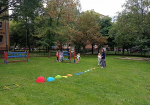 Dzieci wykonują ćwiczenia ruchowe w ogrodzie przedszkolnym