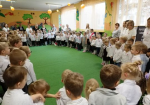 Dzieci i nauczyciele śpiewają hymn państwowy