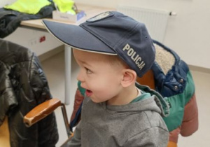 Chłopiec przymierza policyjną czapkę